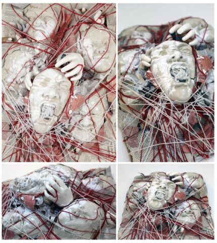 pf_upload 2-1 Mixed media sculpture featuring white plaster cast faces and hands tangled in chaotic red and white strings over shredded newspaper, depicting anguish and confinement through distorted screaming expressions. Four-view documentation.