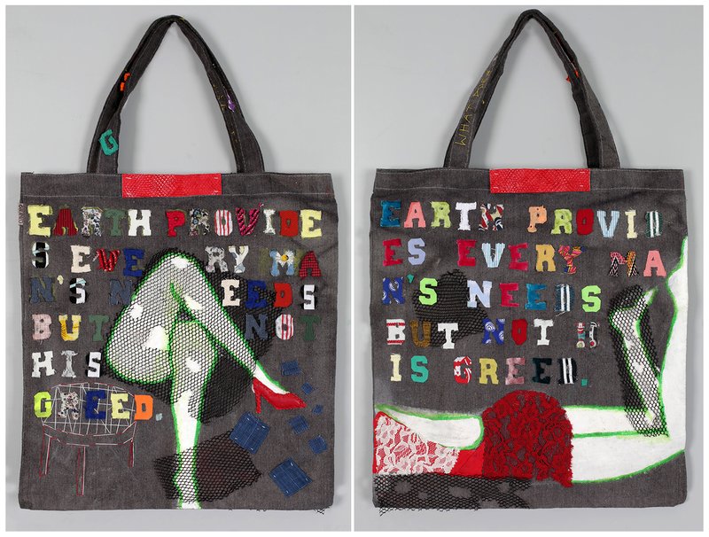 Handcrafted textile tote bag with front and back views featuring mixed fabric lettering spelling "Earth provides every man's needs but not his greed," combined with painted silhouette figures, mesh netting, lace, and patchwork appliqué on dark denim.