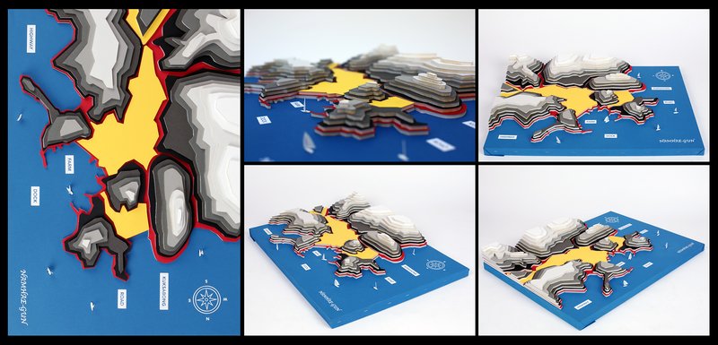 Three-dimensional topographic map model of the Korean peninsula constructed from layered cut paper in gray, white, yellow, and red tones mounted on a blue base, photographed from flat overhead and multiple angled perspectives.