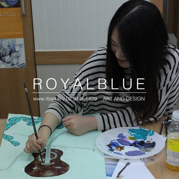 Royal Blue branded photograph of a student painting at a table, viewed from above, showing the student working on a detailed figurative or still life artwork with paintbrushes