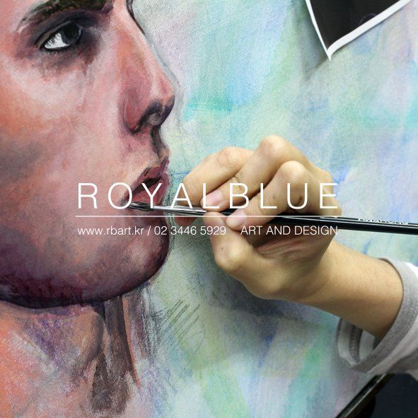 Royal Blue branded close-up photograph of a student's hands carefully painting a hyper-realistic portrait face with fine details, showing precise brushwork on a large canvas