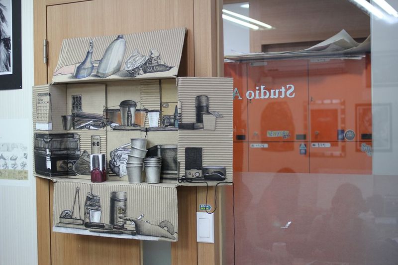 Interior photograph of a Royal Blue studio storage area showing organized shelves with stacked art canvases, framed artworks, and supply boxes alongside a prominent branded sign