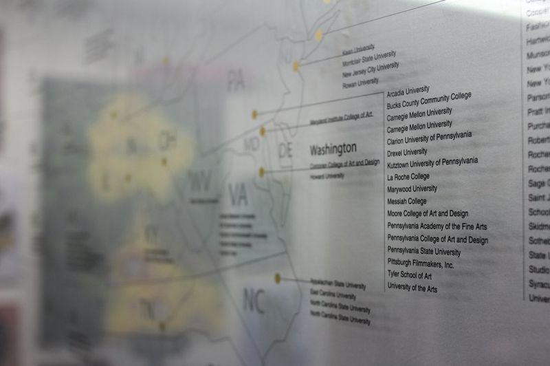 Interior photograph of a Royal Blue studio event or exhibition space with walls covered in promotional posters, program information sheets, and exhibition announcements from past events