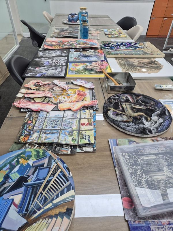 Portfolio artwork spread on studio table at Royal Blue Art & Design, Apgujeong Seoul - artist statement preparation
