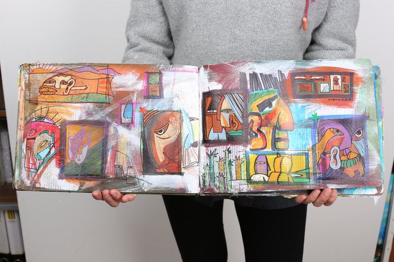 Art student holding expressive sketchbook portfolio at Royal Blue Art & Design, Seoul - preparing for CalArts and LA art school admissions